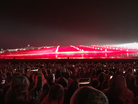 YANGSHUO, CHINA - MARCH 28, 2017: tourists on night light show with natural scene in Yangshuo city in rain. Town is resort destination for domestic and foreign tourists because of scenic karst peaksのeditorial素材