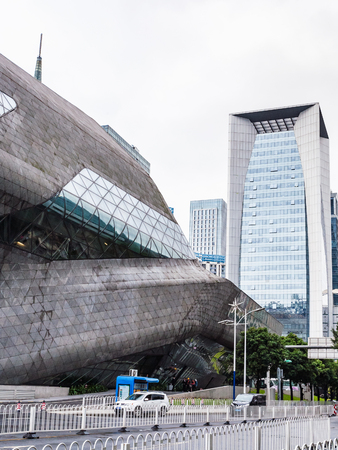 GUANGZHOU, CHINA - MARCH 31, 2017: wall of Opera House and modern houses in Zhujiang New Town of Guangzhou city in spring. Theater was designed by Zaha Hadid, and opened in 2010.のeditorial素材