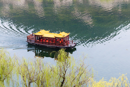 LUOYANG, CHINA - MARCH 20, 2017: above view of passenger boat in Yi river between West and East Hills of Chinese Buddhist monument Longmen Grottoes ( Longmen Caves) in spring seasonのeditorial素材