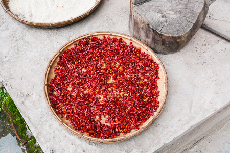 travel to China - pieces of red hot pepper on plate dry outdoors in Chengyang village of Sanjiang Dong Autonomous County in spring seasonの写真素材
