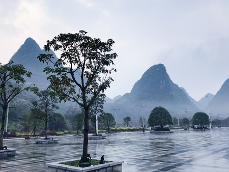 travel to China - wet square and view of karst peaks in Xing Ping town in Yangshuo county in spring rainの写真素材