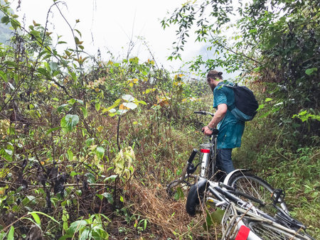 travel to China - bicyclist on overgrown slope of karst mountain in Yangshuo County in spring seasonの写真素材