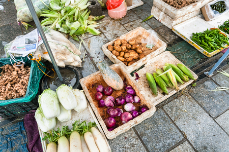 YANGSHUO, CHINA - MARCH 30, 2017: fresh local vegetables on street outdoor market in Yangshuo city in spring. Town is resort destination for domestic and foreign tourists because of scenic karst peaksのeditorial素材