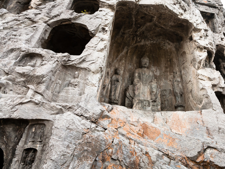 LUOYANG, CHINA - MARCH 20, 2017: relief statues in cave in West Hill of Chinese Buddhist monument Longmen Grottoes. The complex was inscribed upon the UNESCO World Heritage List in 2000のeditorial素材
