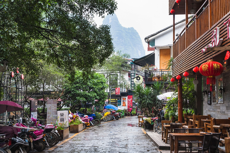 YANGSHUO, CHINA - MARCH 30, 2017: people and cafe on alley in Yangshuo town in spring. Town is resort destination for domestic and foreign tourists because of scenic karst peaksのeditorial素材