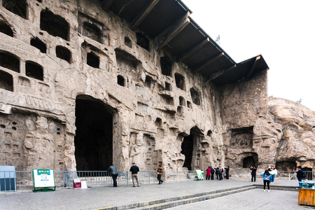 LUOYANG, CHINA - MARCH 20, 2017: tourists near hall in caves of West Hill of Chinese Buddhist monument Longmen Grottoes. The complex was inscribed upon the UNESCO World Heritage List in 2000のeditorial素材