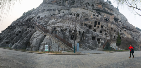 LUOYANG, CHINA - MARCH 20, 2017: tourist and panorama of West Hill with caves in Chinese Buddhist monument Longmen Grottoes. The complex was inscribed upon the UNESCO World Heritage List in 2000のeditorial素材