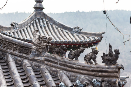 LUOYANG, CHINA - MARCH 20, 2017: roof decoration of temple on East Hill of Chinese Buddhist monument Longmen Grottoes in spring. The complex was inscribed upon the UNESCO World Heritage List in 2000のeditorial素材