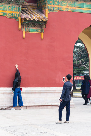 BEIJING, CHINA - MARCH 19, 2017: tourists take photo near gate in Imperial Ancestral Hall public park in Beijing Imperial city in spring. This park is part of Forbidden City green areaのeditorial素材
