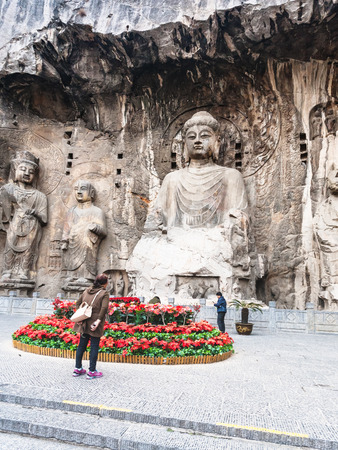 LUOYANG, CHINA - MARCH 20, 2017: people near carved The Big Vairocana statue in main Longmen Grotto (Longmen Caves). The complex was inscribed upon the UNESCO World Heritage List in 2000のeditorial素材