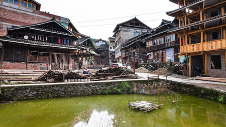 CHENGYANG, CHINA - MARCH 27, 2017: canal and street near residential houses in Chengyang village of Sanjiang Dong Autonomous County in spring. Chengyang includes eight villages of the Dong peopleのeditorial素材