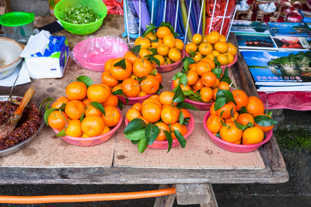 XINGPING, CHINA - MARCH 30, 2017: fresh mandarines on stall in market in Xing Ping town in Yangshuo county. The town was settled in 265 AD, Xingping is surrounded by great examples of Karst peaksのeditorial素材