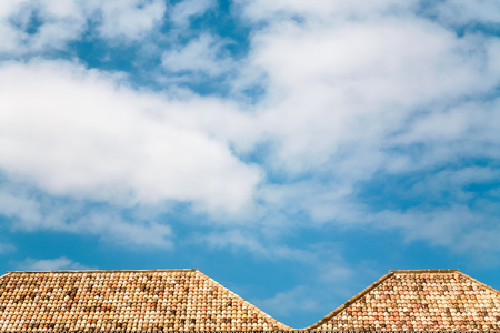 Travel to Algarve Portugal - white clouds in blue sky over orange tile roofs of house in Faro cityの写真素材