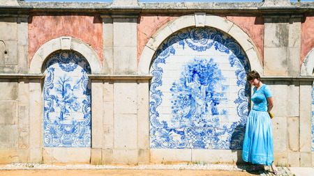 Travel to Algarve Portugal - tourist near outside wall of Estoi Palace with traditional azulejo tile decor in Estoi village. The Palace was built in the late 19th centuryの写真素材