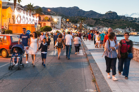 GIARDINI NAXOS, ITALY - JULY 2, 2017: people walk on waterfront in Giardini-Naxos city in summer evening. Giardini Naxos is seaside resort on Ionian Sea coast since the 1970sのeditorial素材