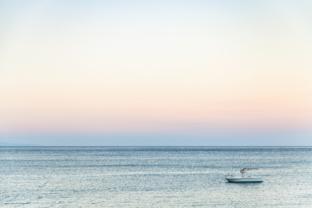 travel to Sicily, Italy - view of boat in Ionian sea near Giardini Naxos town in summer eveningの写真素材