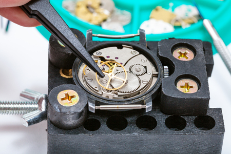 watchmaker workshop - repairing of old watch in holder with tweezer close upの写真素材