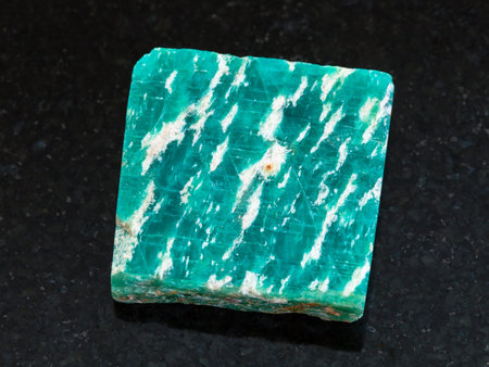 macro shooting of natural mineral rock specimen - raw amazonite stone on dark granite background