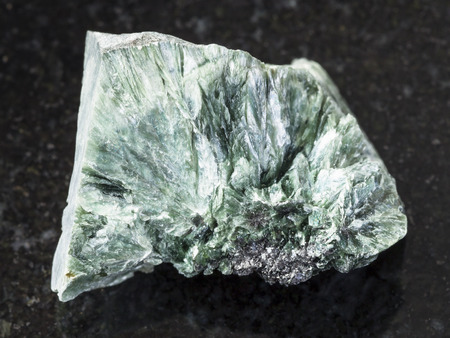 macro shooting of natural mineral rock specimen - rough clinochlore stone on dark granite background from Korshunovskoe mine, Irkutsk region, Russiaの写真素材