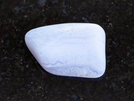 macro shooting of natural mineral rock specimen - polished blue lace agate (chalcedony, sapphirine) gemstone on dark granite backgroundの写真素材