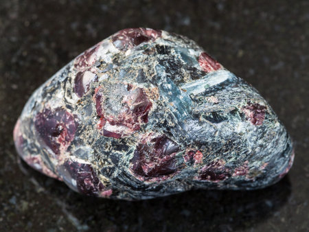 macro shooting of natural mineral rock specimen - polished Almandine garnet and biotite crystals in...