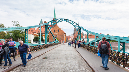 WROCLAW, POLAND - SEPTEMBER 12, 2017: tourists on pedestrian Tumski Bridge (Most Tumski, Lovers Bridge, Cathedral Bridge, Green Bridge) over Oder river to Ostrow Tumski island in Wroclaw cityのeditorial素材