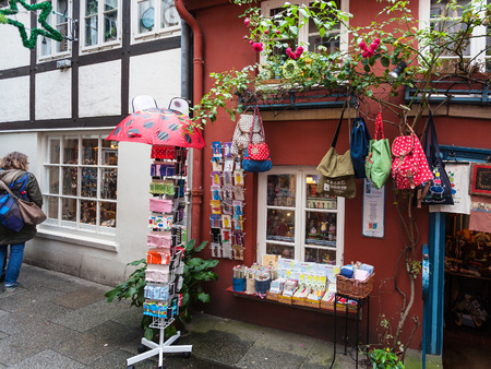 BREMEN, GERMANY - SEPTEMBER 16, 2017: tourist near gift shop in Schnoor quarter in rain. Schnoor is a district in the medieval centre of Bremen cityのeditorial素材