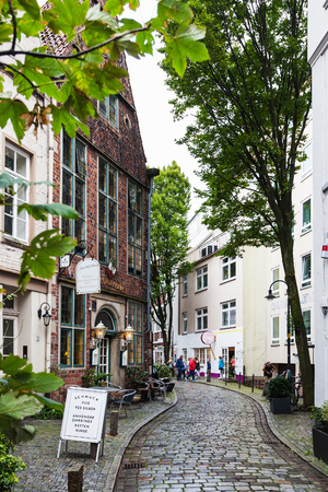 BREMEN, GERMANY - SEPTEMBER 16, 2017: people on narrow alley in Schnoor quarter in rainy day. Schnoor is a district in the medieval centre of Bremen cityのeditorial素材