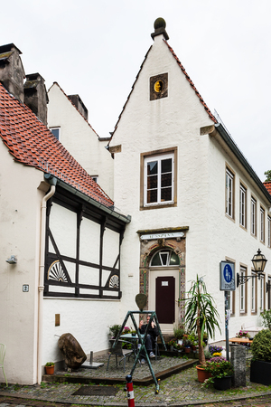 BREMEN, GERMANY - SEPTEMBER 16, 2017: man near old urban house in Schnoor quarter in rain. Schnoor is a district in the medieval centre of Bremen cityのeditorial素材