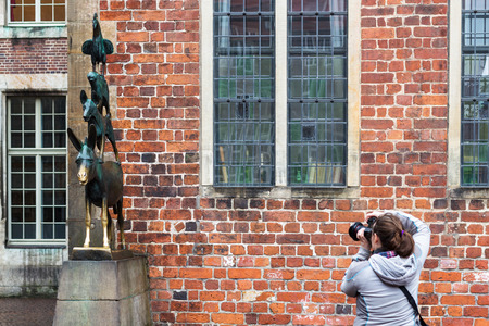 BREMEN, GERMANY - SEPTEMBER 16, 2017: photographer takes photo of bronze statue of Bremen Town Musicians in Bremen city in autumn. The statue was erected in 1953 by sculptor Gerhard Marcksのeditorial素材