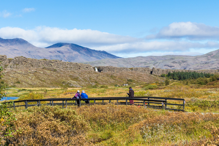 THINGVELLIR, ICELAND - SEPTEMBER 6, 2017: people on bridge over Oxara river in Thingvellir. Thingvellir is historical, cultural, and geological site, it is one of the most popular tourist destinationsのeditorial素材