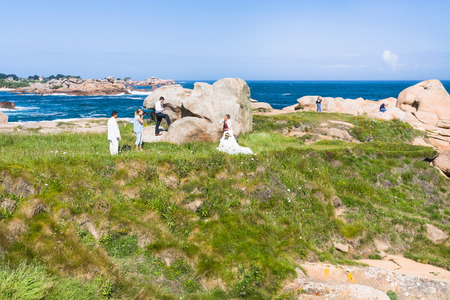 PERROS-GUIREC, FRANCE - JULY 3, 2010: traditional wedding photosession in Ploumanac'h site of Perros-Guirec commune on Pink Granite Coast of Cotes-d'Armor department of Brittany in sunny summer dayのeditorial素材