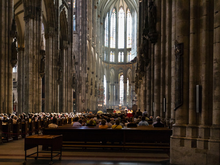 COLOGNE, GERMANY - JUNE 27, 2010: visitors in church service in Cologne Cathedral. The Cathedral is Germany's most visited landmark, attracting an average of 20000 people a dayのeditorial素材