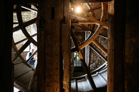 LE MONT SAINT-MICHEL - JULY 5, 2010: visitors near well wheel in Saint Michael's Abbey. Le Mont Saint-Michel is an island commune in Normandy, first monastic on the mount was built in the 8th centuryのeditorial素材