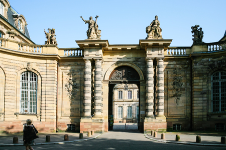 STRASBOURG, FRANCE - JULY 10, 2010: woman near wing of Rohan Palace with gate to Strasbourg city museums - Archaeological Museum, Museum of Decorative Arts and Museum of Fine Arts in summer eveningのeditorial素材