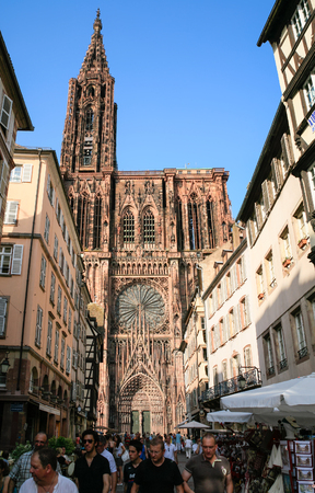 STRASBOURG, FRANCE - JULY 10, 2010: people on street Rue Merciere and view of west facade of Strasbourg Cathedral. Roman Catholic cathedral was built in 1015-1439 years in Romanesque and Gothic stylesのeditorial素材