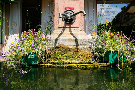 RIQUEWIHR, FRANCE - JULY 11, 2010: old water spring in Riquewihr city. Riquewihr is commune in Alsace Wine Route region, the town belongs to the association The most beautiful villages of Franceのeditorial素材