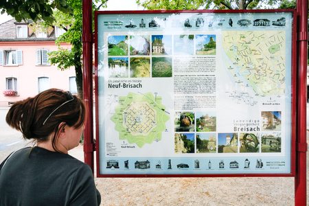 NEUF-BRISACH, FRANCE - JULY 11, 2010: tourist look on map of Neuf-Brisach on the Place d'Armes General de Gaulle. Neuf-Brisach is a fortified town and commune in the Haut-Rhin department in Alsaceのeditorial素材