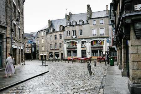 DINAN, FRANCE - JULY 5, 2010: tourist on square Place des Merciers with wet pavement in Dinan city in rain. Dinan is a walled town and commune in the Cotes-d'Armor department of Brittanyのeditorial素材