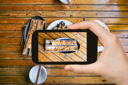 travel concept - tourist photographs local chinese food fried rice in bamboo plank in rural eatery in area Dazhai Longsheng (Dragon's Backbone, Longji) Rice Terraces in China on smatphoneの写真素材