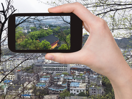 travel concept - tourist photographs above view of Guilin city in China in spring evening on smartphoneの写真素材