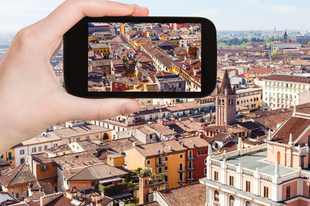 travel concept - tourist photographs Verona cityscape in Italy from tower Torre dei Lamberti in spring on smartphoneの写真素材