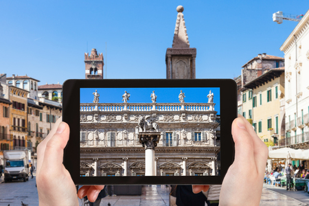 travel concept - tourist photographs square Piazza delle Erbe in Verona city in Italy on tabletの写真素材