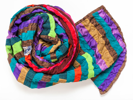 rolled stitched patchwork scarf from silk bands on white backgroundの写真素材