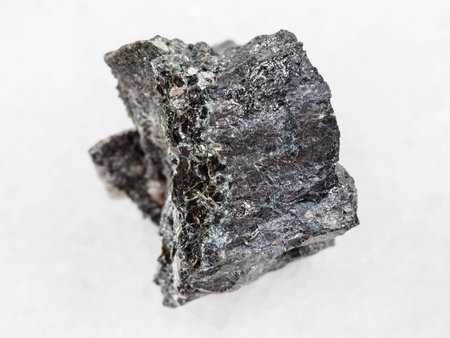 macro shooting of natural mineral rock specimen - raw Magnetite ore on white marble background from...