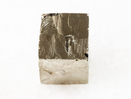 macro shooting of natural mineral rock specimen - rough pyrite crystal on white marble background...