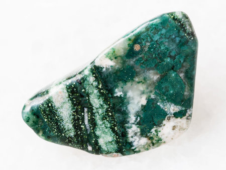 macro shooting of natural mineral rock specimen - polished Chlorite gemstone on white marble...