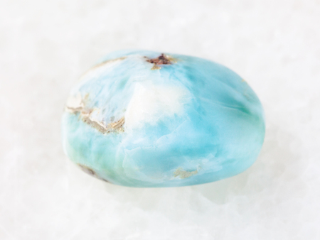 macro shooting of natural mineral rock specimen - tumbled Larimar gemstone on white marble background from Dominican Republicの写真素材