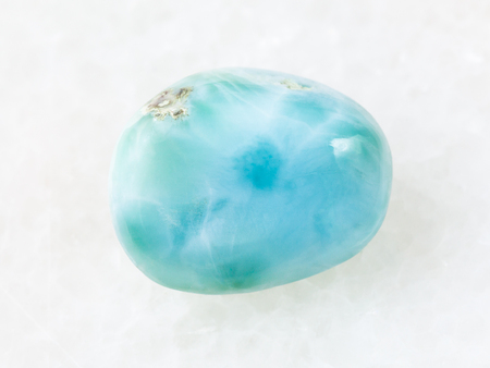 macro shooting of natural mineral rock specimen - polished Larimar gemstone on white marble background from Dominican Republicの写真素材