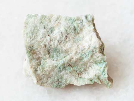 macro shooting of natural mineral rock specimen - rough Listwanite stone on white marble backgroundの写真素材